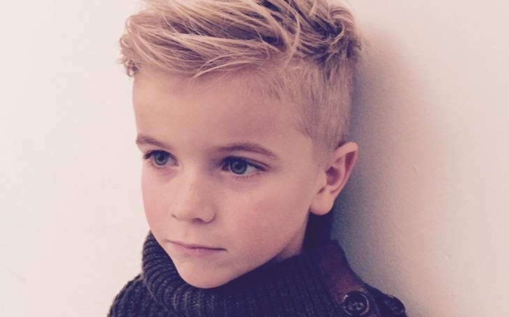 Chłopiec z modną fryzurą, patrzy w dal.