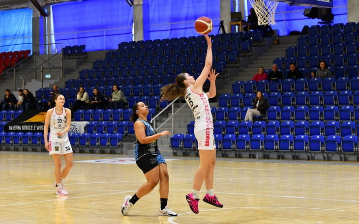 Koszykarka wykonująca rzut w trakcie meczu.