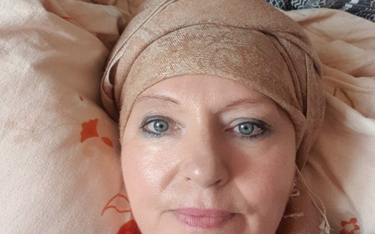 Kobieta w chustce, z wyrazem spokoju na twarzy.