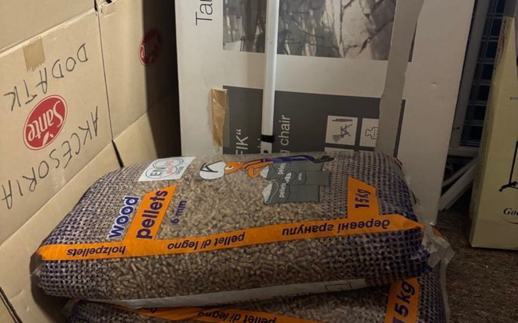 Worki z pelletem drzewnym wśród kartonów.