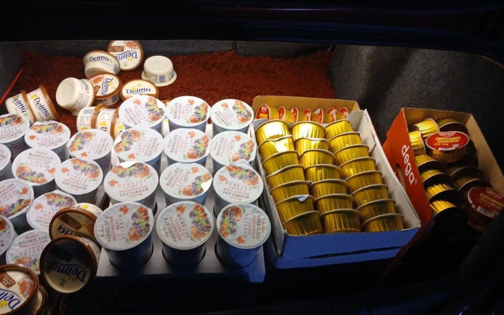 Bagażnik samochodu wypełniony różnymi produktami spożywczymi.