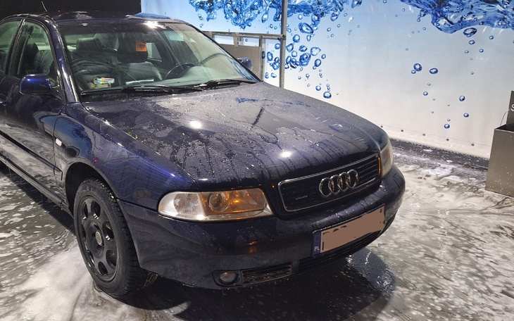 Samochód na myjni, pokryty pianą.