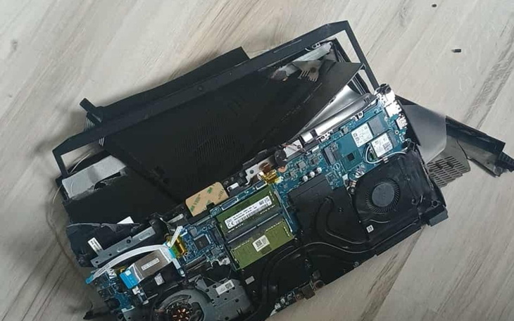 Uszkodzony laptop z widocznymi podzespołami wewnętrznymi.