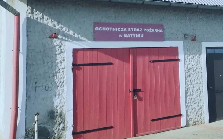 Budynek straży pożarnej z czerwonymi drzwiami.
