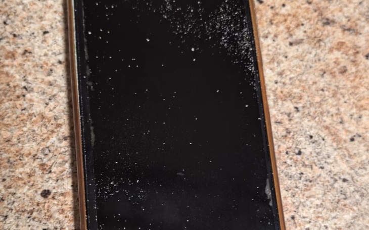 Zabrudzony ekran telefonu leżący na blacie.