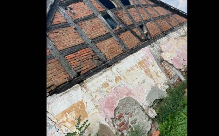 Zniszczony budynek z cegły, z widocznymi śladami upływu czasu.