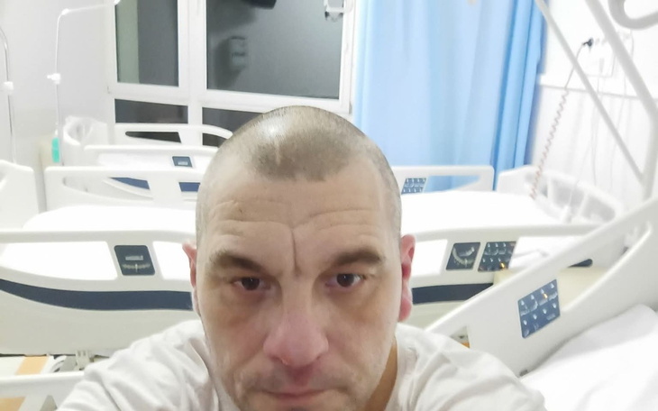 Mężczyzna w szpitalu z krótkimi włosami i smutnym wyrazem twarzy.