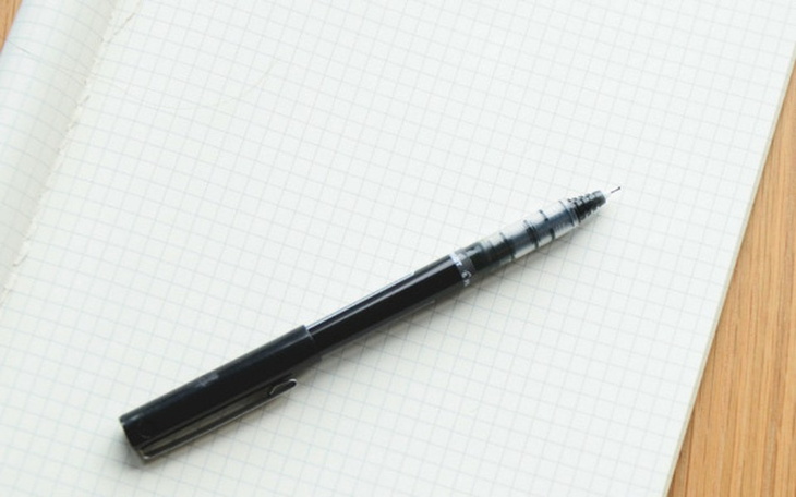 Długopis leżący na pustej kartce w kratkę.