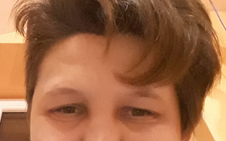 Zbliżenie na twarz osoby, uśmiechającej się do kamery.