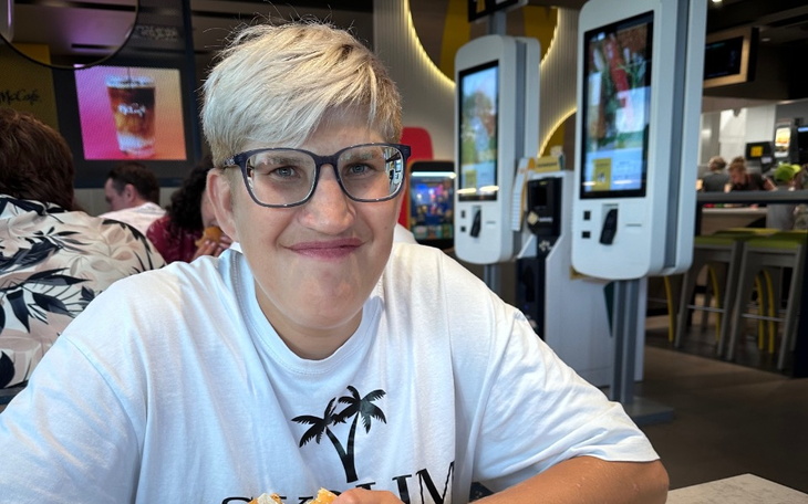 Kobieta w restauracji, uśmiechająca się do kamery.