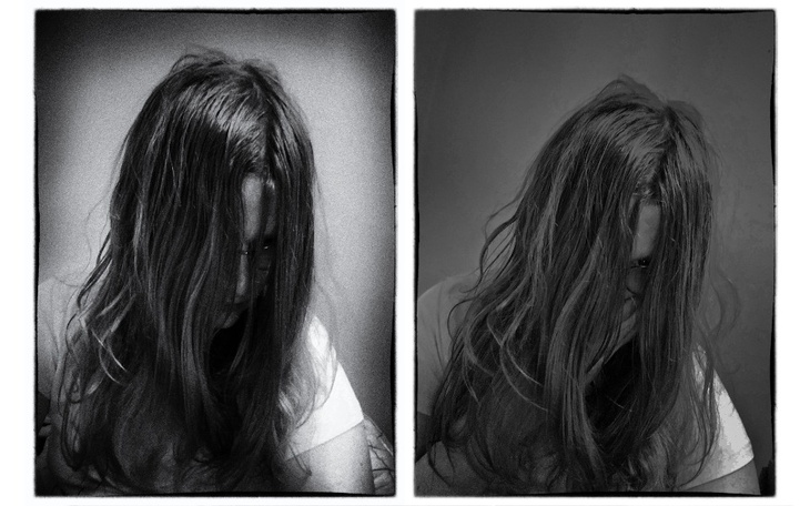 Czarno-białe zdjęcie osoby z długimi włosami, w zamyśleniu.