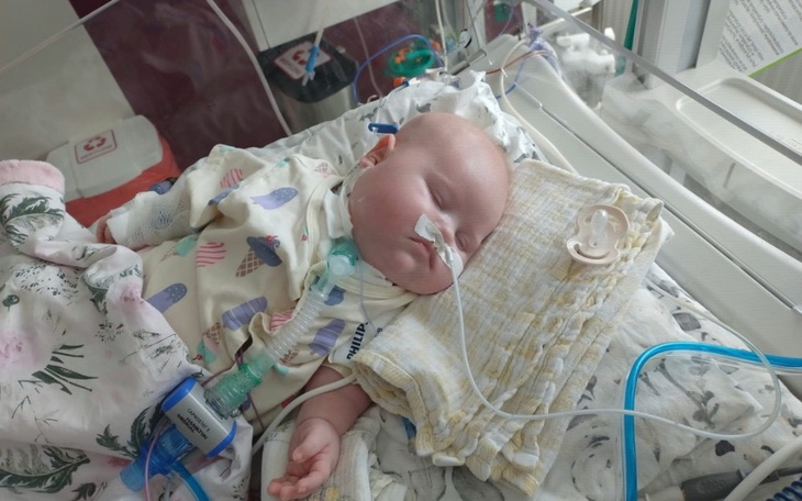 Małe dziecko śpiące w szpitalnym łóżku.