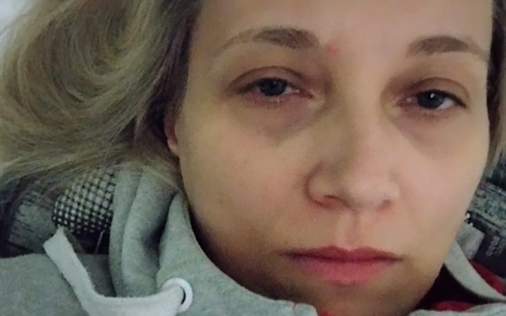 Osoba leżąca na łóżku, zmęczona i z zamkniętymi oczami.