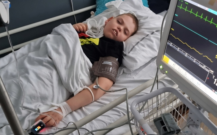 Chłopiec leży w szpitalnym łóżku, podłączony do monitorów.