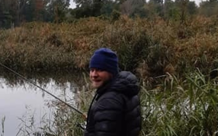 Mężczyzna łowiący ryby nad brzegiem rzeki.