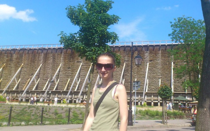 Młoda kobieta na tle zabytkowej budowli.