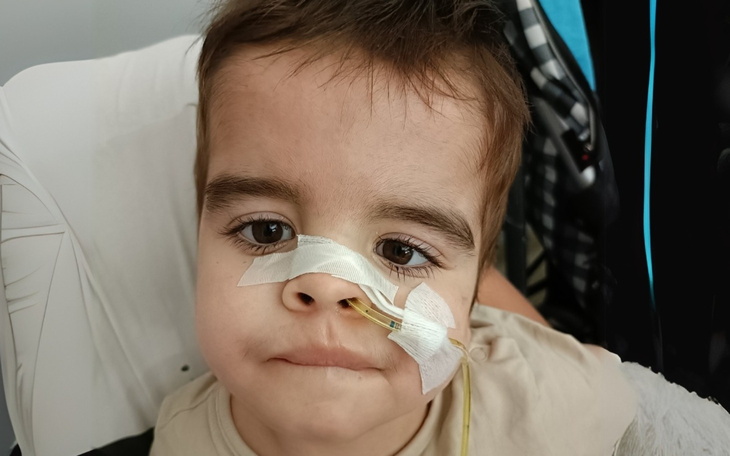 Chłopiec z rurką nosową, potrzebujący pomocy medycznej.