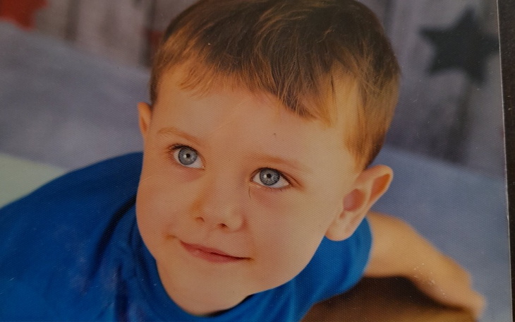 Dziewczynka z maskotką, patrząca przez okno.