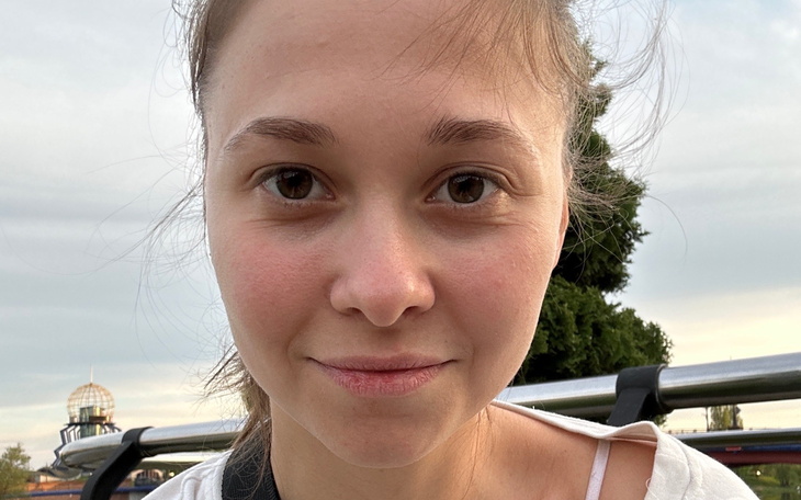 Młoda kobieta z naturalnym uśmiechem, pozująca na tle nieba.