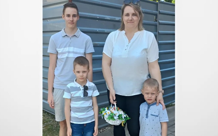 Rodzina z dwoma chłopcami, trzymający koszyk z kwiatami.