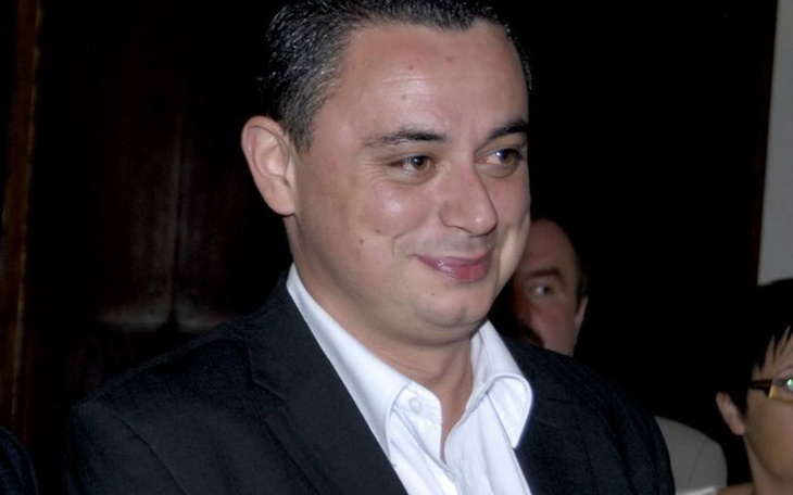 Mężczyzna w garniturze, uśmiechający się do kamery.