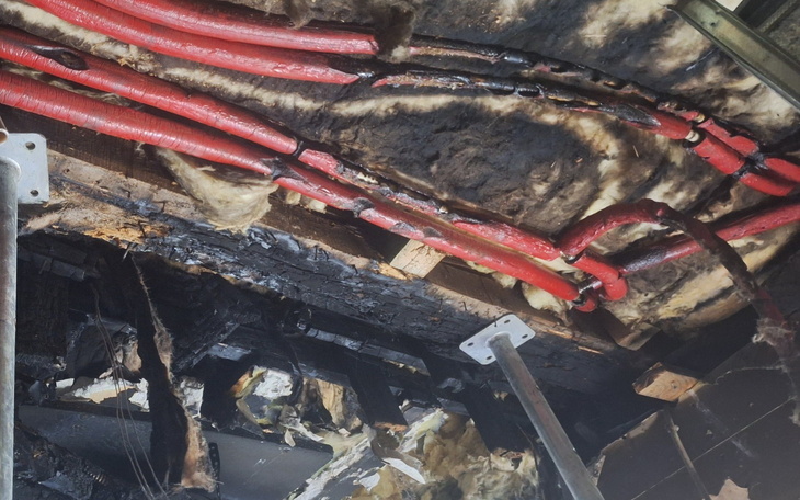 Zniszczona instalacja elektryczna po pożarze, pokazująca skutki katastrofy.