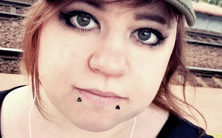 Portret dziewczyny z wyrazistym makijażem i kolczykami.