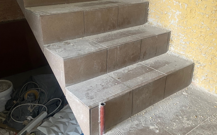 Schody w trakcie remontu, pokryte kurzem i pyłem.