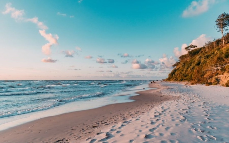 Plaża o zachodzie słońca z delikatnymi falami.