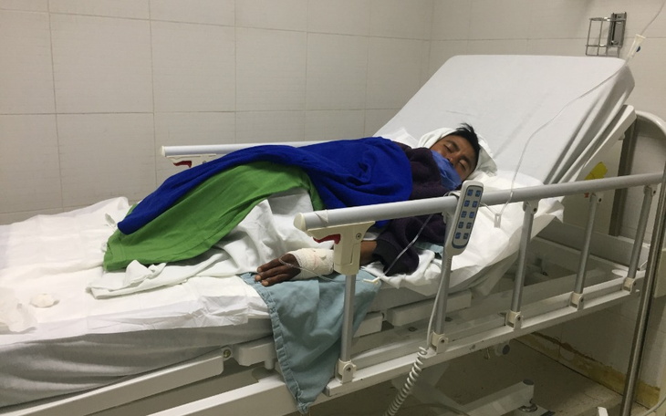 Chłopiec leżący na łóżku szpitalnym, przykryty kocem.