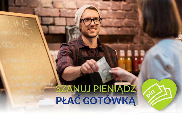 Mężczyzna przy ladzie, przyjmujący płatność gotówką.