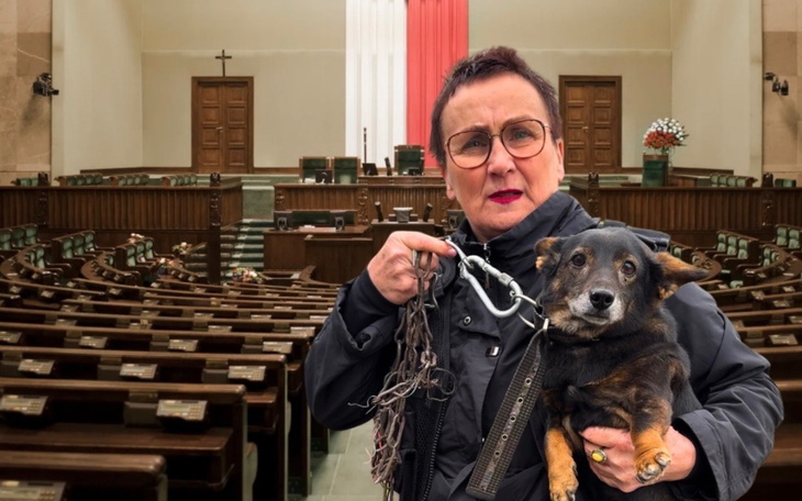 Kobieta z psem w sali obrad, trzymająca smycz.