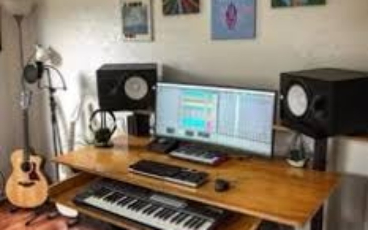 Nowoczesne studio nagrań z komputerem, klawiaturą i instrumentami.