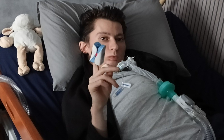 Młody mężczyzna leżący w łóżku z urządzeniem medycznym.