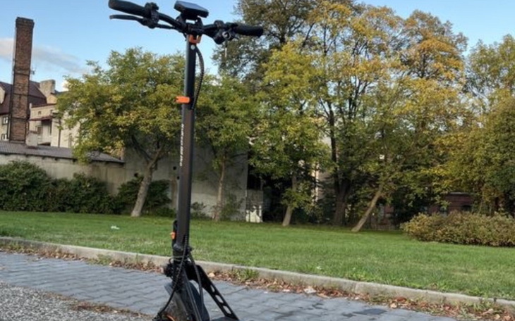 Hulajnoga elektryczna na tle zielonego parku.