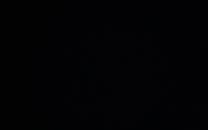 Widok na zniszczony dom po powodzi, z gruzem na podwórku.