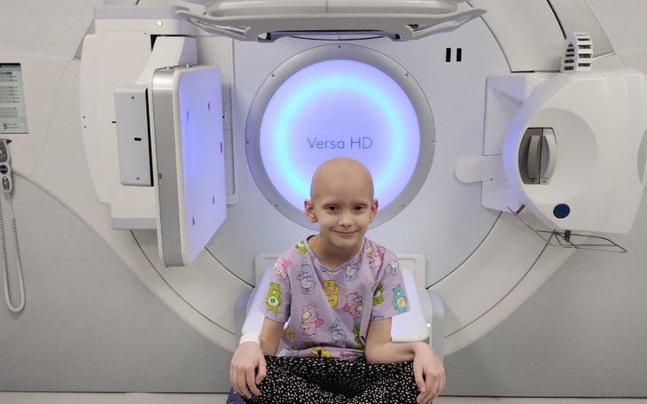 Chłopiec w szpitalu, czekający na terapię, z uśmiechem.