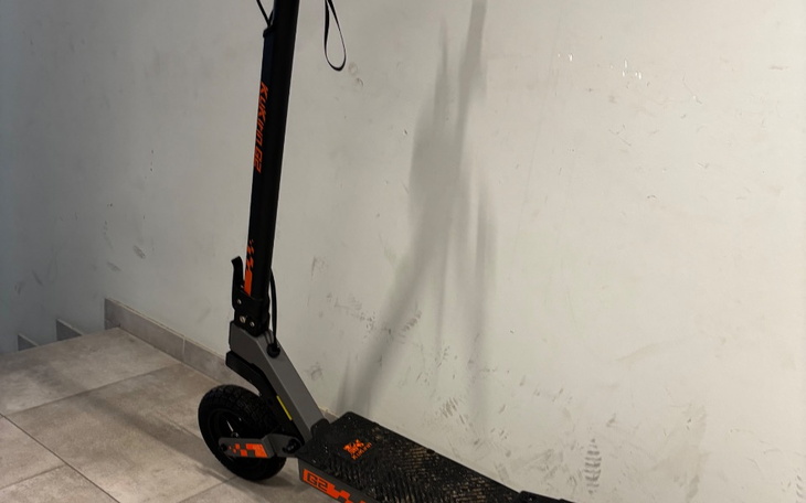 Skuter elektryczny stojący na podłodze w jasnym pomieszczeniu.