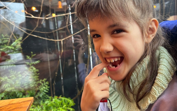 Uśmiechnięta dziewczynka pokazująca zęby.