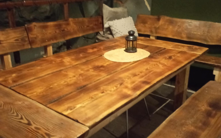 Drewniany stół z lampionem w środku.