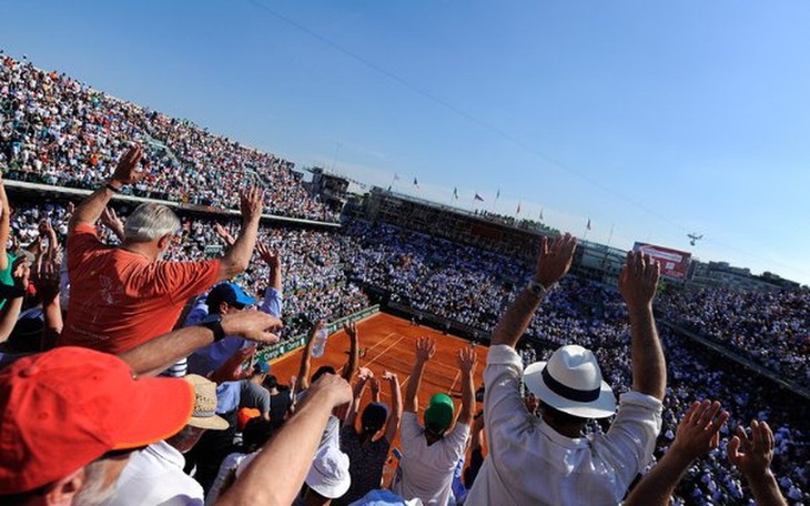 Tłum kibiców na meczu tenisowym, radosna atmosfera.