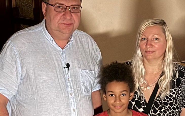 Rodzina pozująca do zdjęcia w przytulnym wnętrzu.