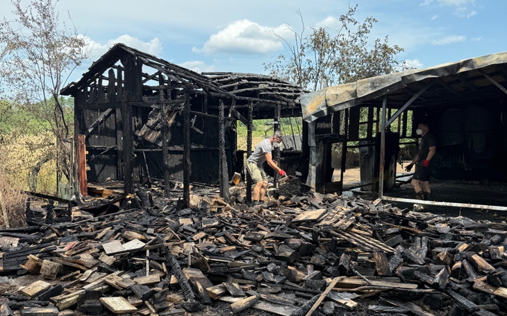 Zniszczony budynek po pożarze, w tle pracujący ludzie.
