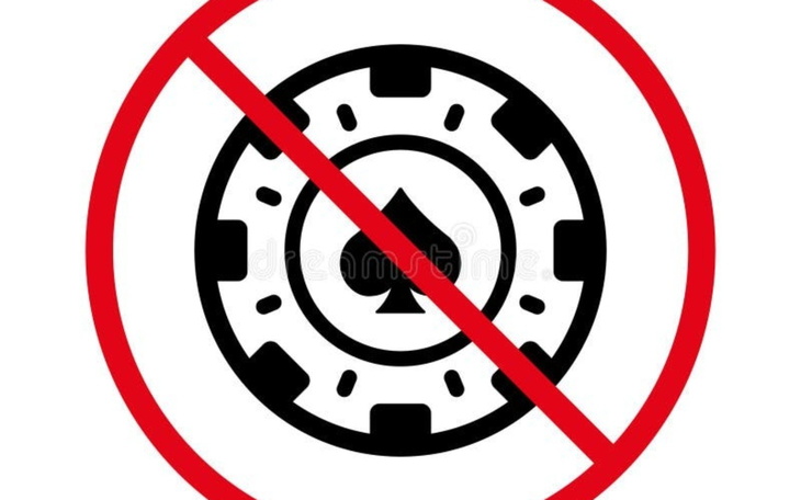 Symbol zakazu hazardu z przekreślonym żetonem.