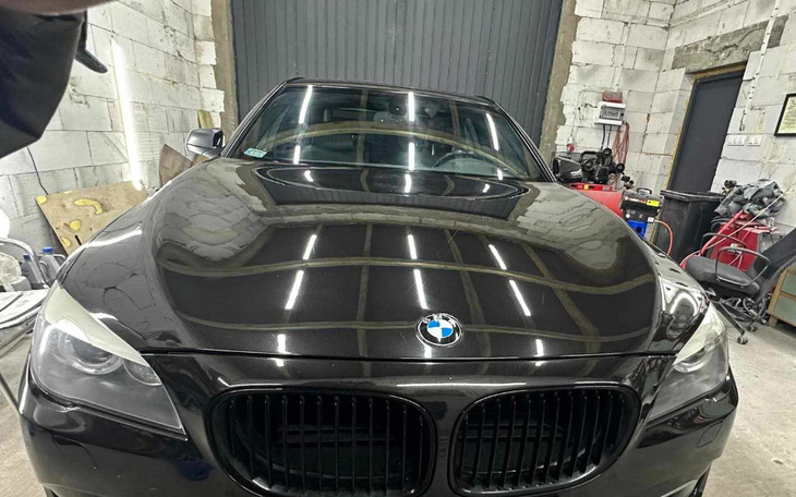 Czarny samochód BMW zaparkowany w warsztacie.