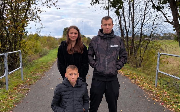 Trójka młodych ludzi na jesiennym spacerze na ścieżce
