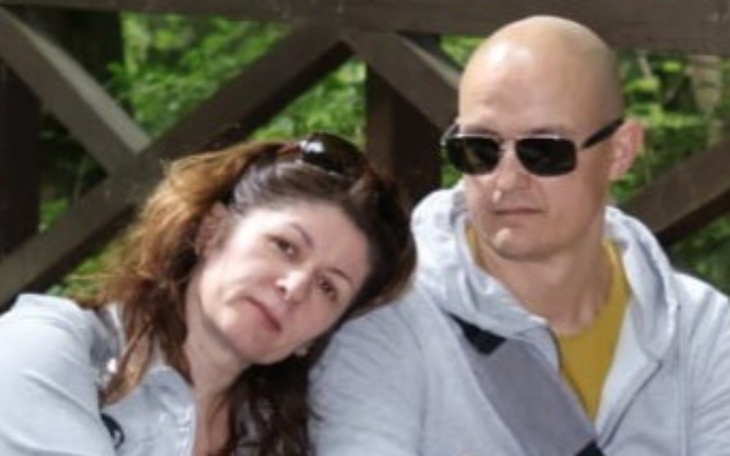 Para ludzi siedząca blisko siebie, w tle zieleń.