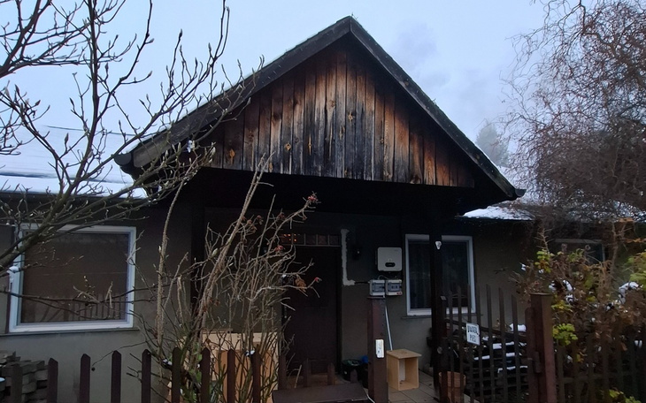 Dom z uszkodzoną elewacją, widoczne ślady po pożarze.