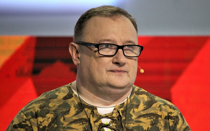 Mężczyzna w okularach, uśmiechający się do kamery.