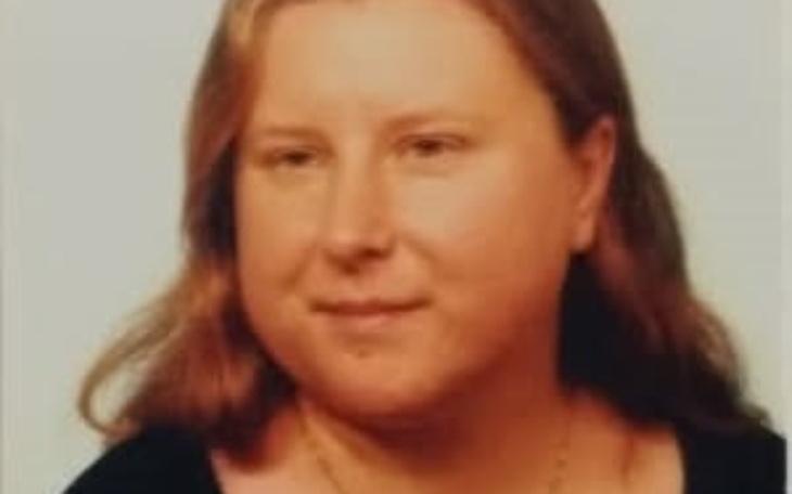 Portret kobiety z długimi włosami, uśmiechającej się do obiektywu.